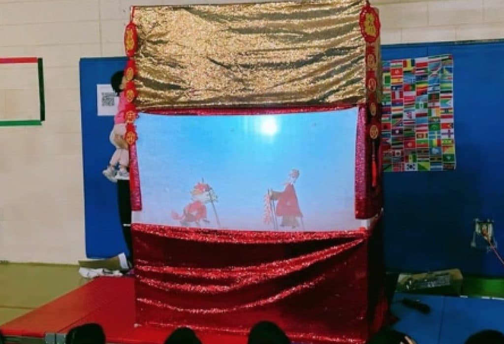 Students exploring the shadow theater stage